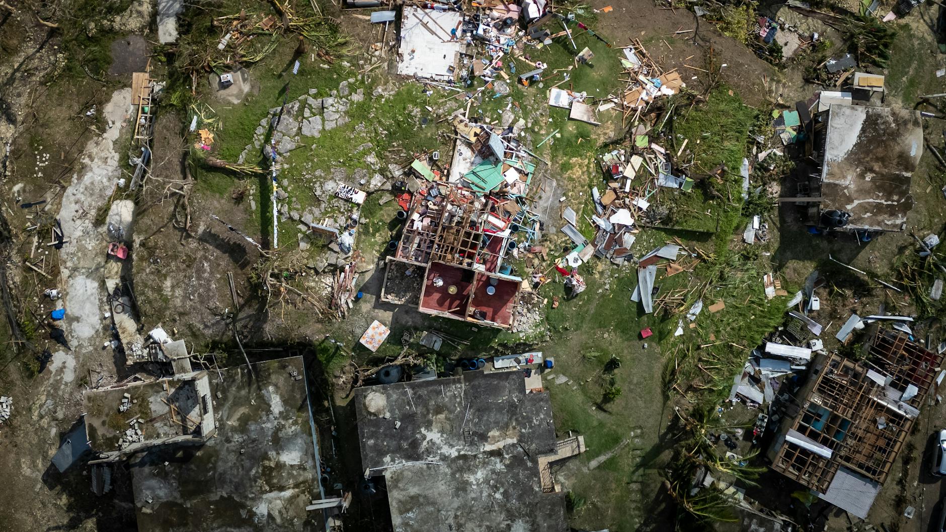 Storm-damaged residential roof with missing and torn shingles