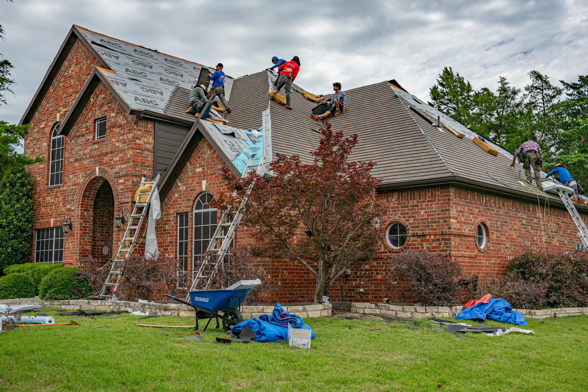 Roofing crew performing a full tear-off and replacement on a residential roof